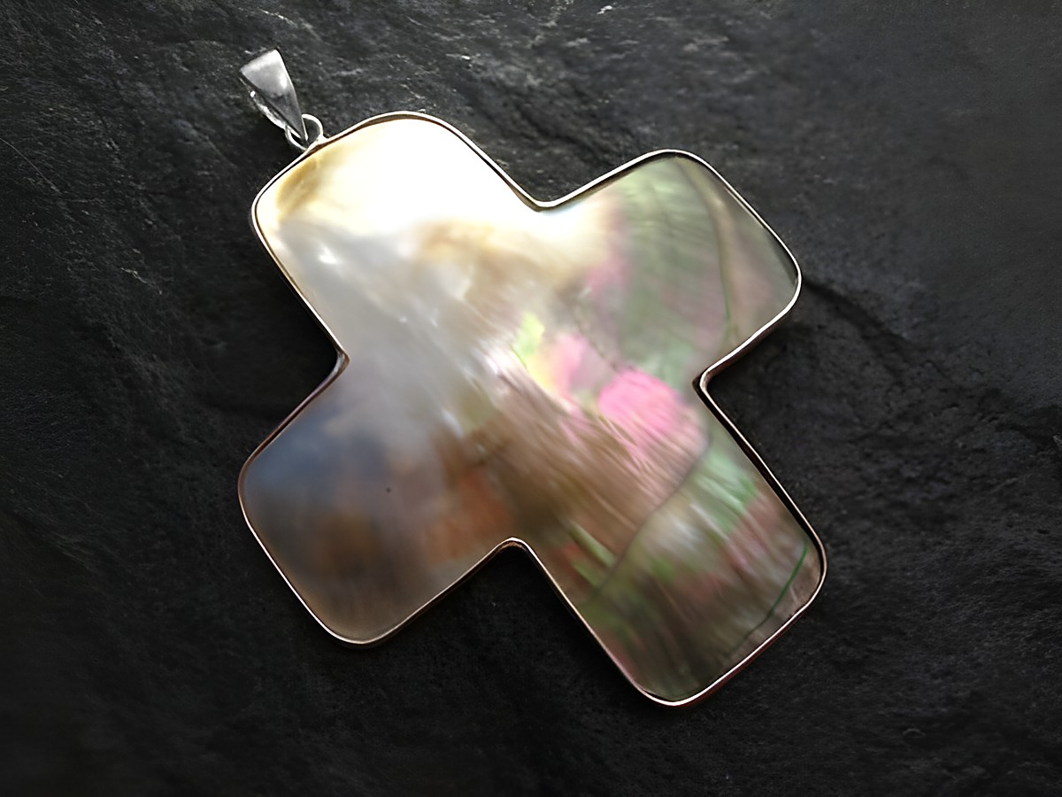 Perlmutt Kreuz Anhänger mit einem Durchmesser von 6 cm, Silberrand und Öse, hergestellt von Juwelier Harnisch, in schimmernden Farben des Perlmutt.