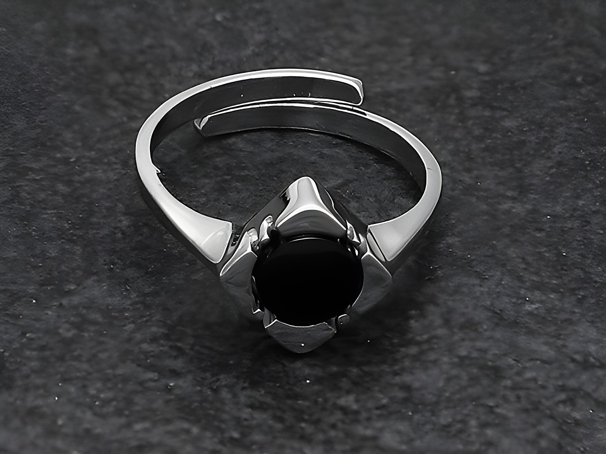 Silberring mit verstellbarem Band, im Mittelpunkt ein schwarzer Onyx, umgeben von rhodiniertem Metall, elegant und puristisch gestaltet, ideal für jeden Anlass.