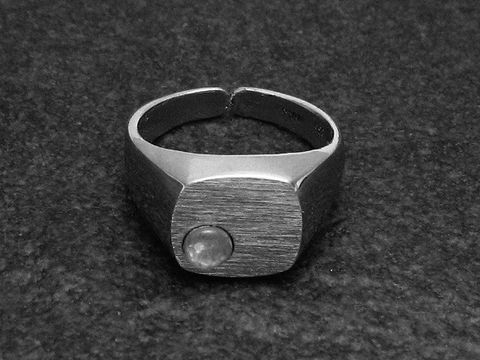 Silberring mit quadratischem, mattem Kopf und rundem, opalen Stein, größenverstellbar, rhodiniert, hergestellt von Juwelier Harnisch.