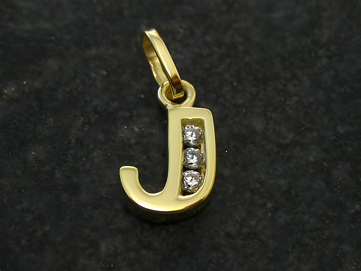 Goldanhänger in Form des Buchstabens J mit drei Zirkonia besetzt, hergestellt von Juwelier Harnisch. Ideal als persönliches Schmuckstück oder Geschenk.