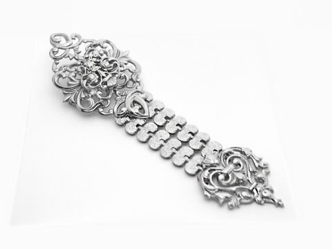 Verschlungene silberne Brosche im neuen Look von Juwelier Harnisch, dekorativer Modeschmuck mit filigranen Mustern und Details, ideal für elegante Akzente.