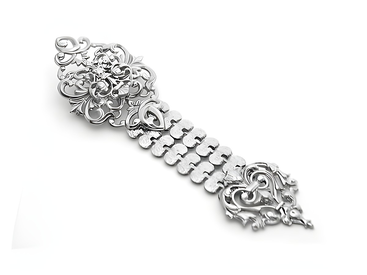 Verschlungene silberne Brosche im neuen Look von Juwelier Harnisch, dekorativer Modeschmuck mit filigranen Mustern und Details, ideal für elegante Akzente.