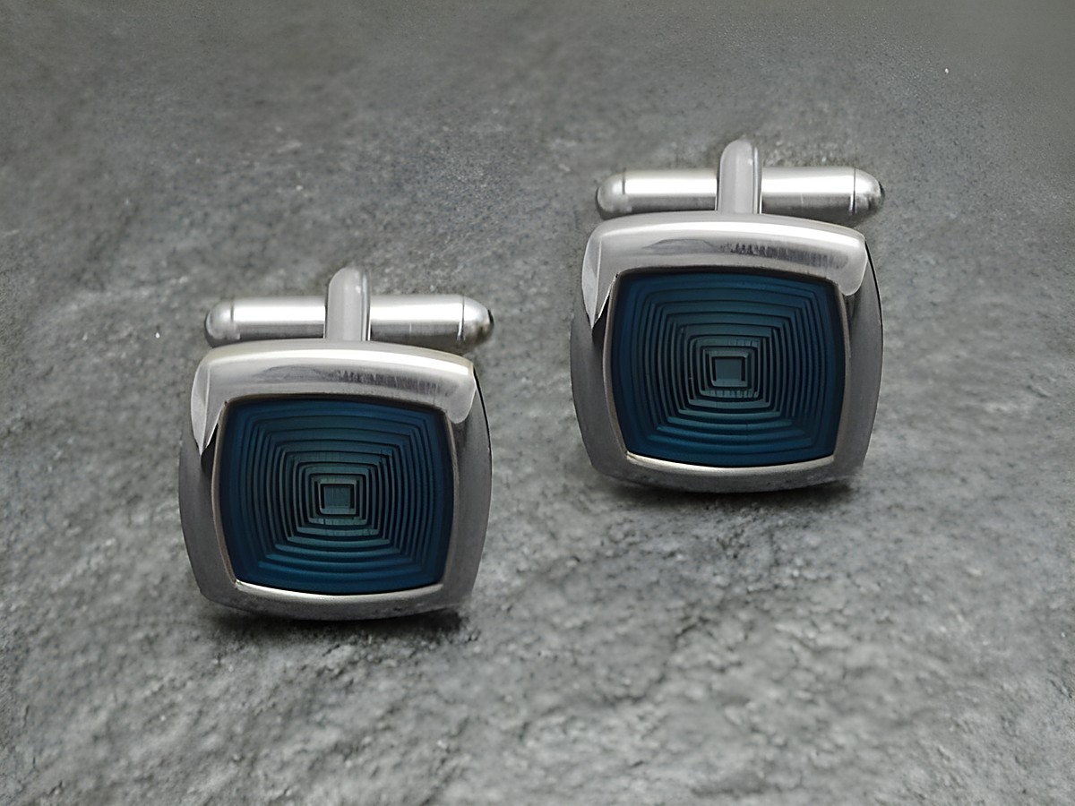 Silberfarbene Manschettenknöpfe im 70er Look mit blauem geometrischen Design, Hersteller Juwelier Harnisch, ideal für einen eleganten Auftritt.