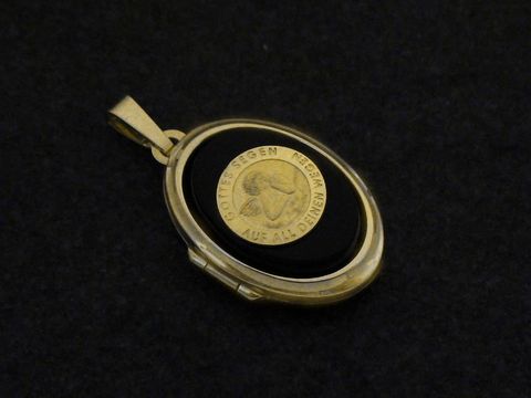 Ein goldfarbenes Medaillon aus Gold 750 mit einem Engel-Motiv auf einem Onyx-Cabochon, Hersteller Juwelier Harnisch, elegant und zeitlos in seiner Gestaltung.