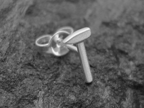 Ein Einzelohrring in Form eines Hammers aus Sterlingsilber, hergestellt von Juwelier Harnisch, ideal für handwerklich begeisterte Personen.