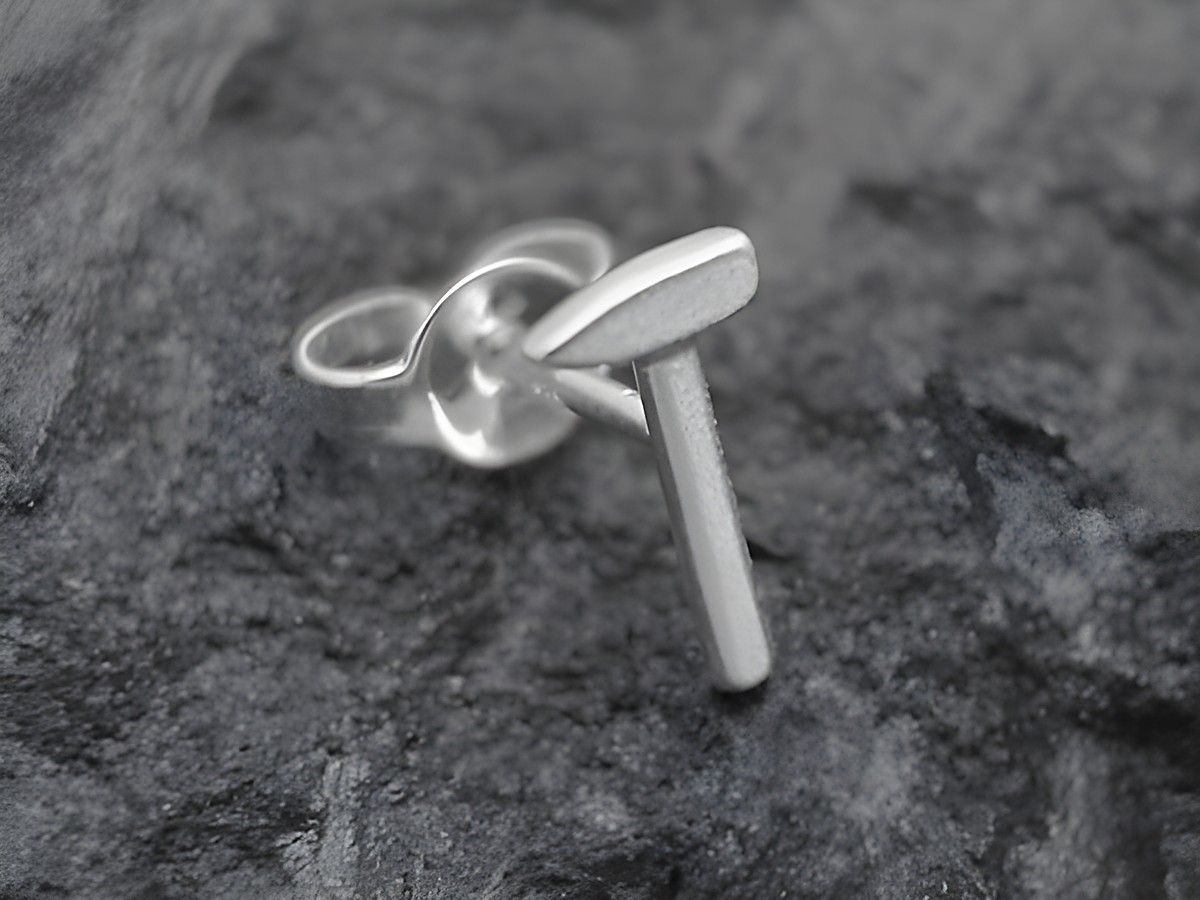 Ein Einzelohrring in Form eines Hammers aus Sterlingsilber, hergestellt von Juwelier Harnisch, ideal für handwerklich begeisterte Personen.