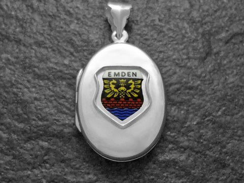 Silbernes Medaillon mit dem Stadtwappen von Emden, dargestellt in bunten Farben auf einer ovalen Fläche, hergestellt von Juwelier Harnisch in Niedersachsen.