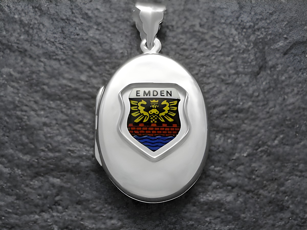 Silbernes Medaillon mit dem Stadtwappen von Emden, dargestellt in bunten Farben auf einer ovalen Fläche, hergestellt von Juwelier Harnisch in Niedersachsen.