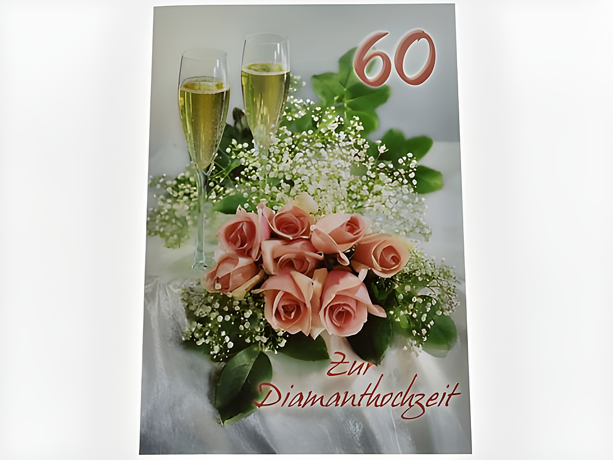 Zwei Sektgläser stehen neben einem zierenden Rosenstrauß auf einer eleganten Unterlage, dekoriert für eine Diamanthochzeit, von Juwelier Harnisch.