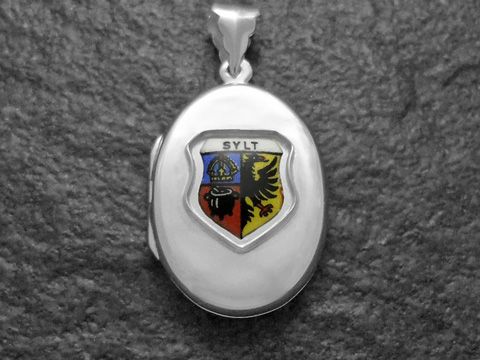 Silbermedaillon mit dem Wappen der Insel Sylt in der Mitte. Das Wappen zeigt eine farbige Darstellung mit Symbolen und dem Schriftzug SYLT. Hergestellt von Juwelier Harnisch.