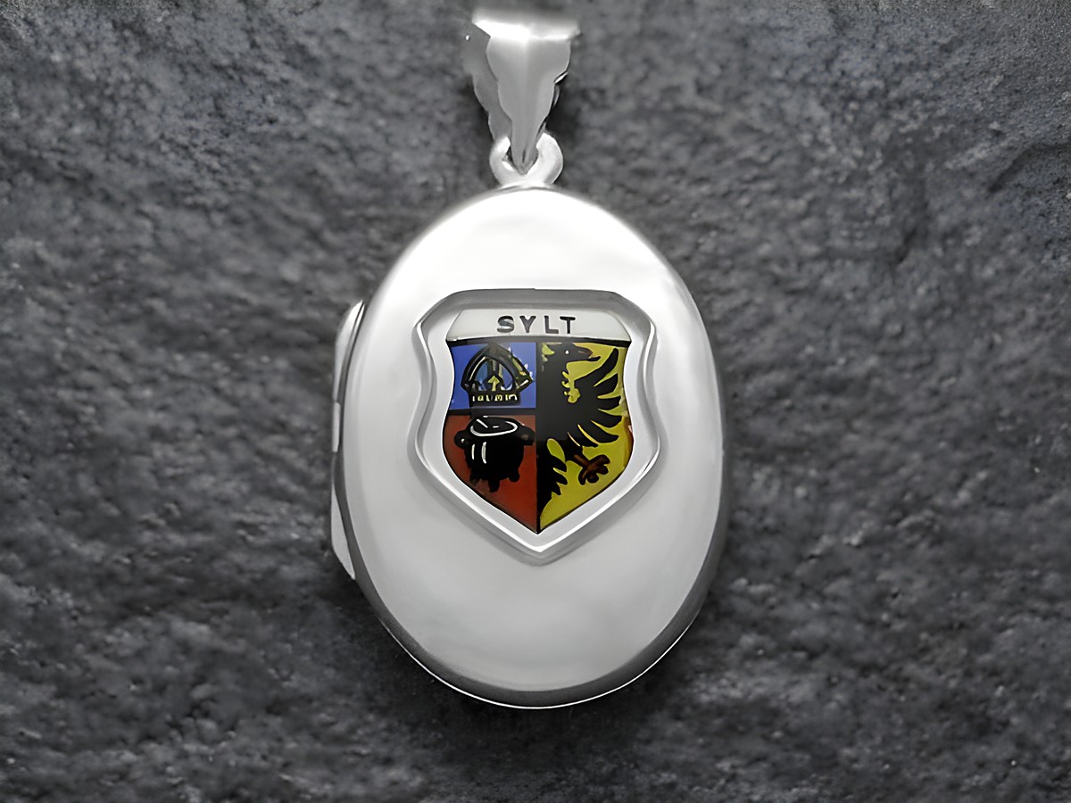 Silbermedaillon mit dem Wappen der Insel Sylt in der Mitte. Das Wappen zeigt eine farbige Darstellung mit Symbolen und dem Schriftzug SYLT. Hergestellt von Juwelier Harnisch.