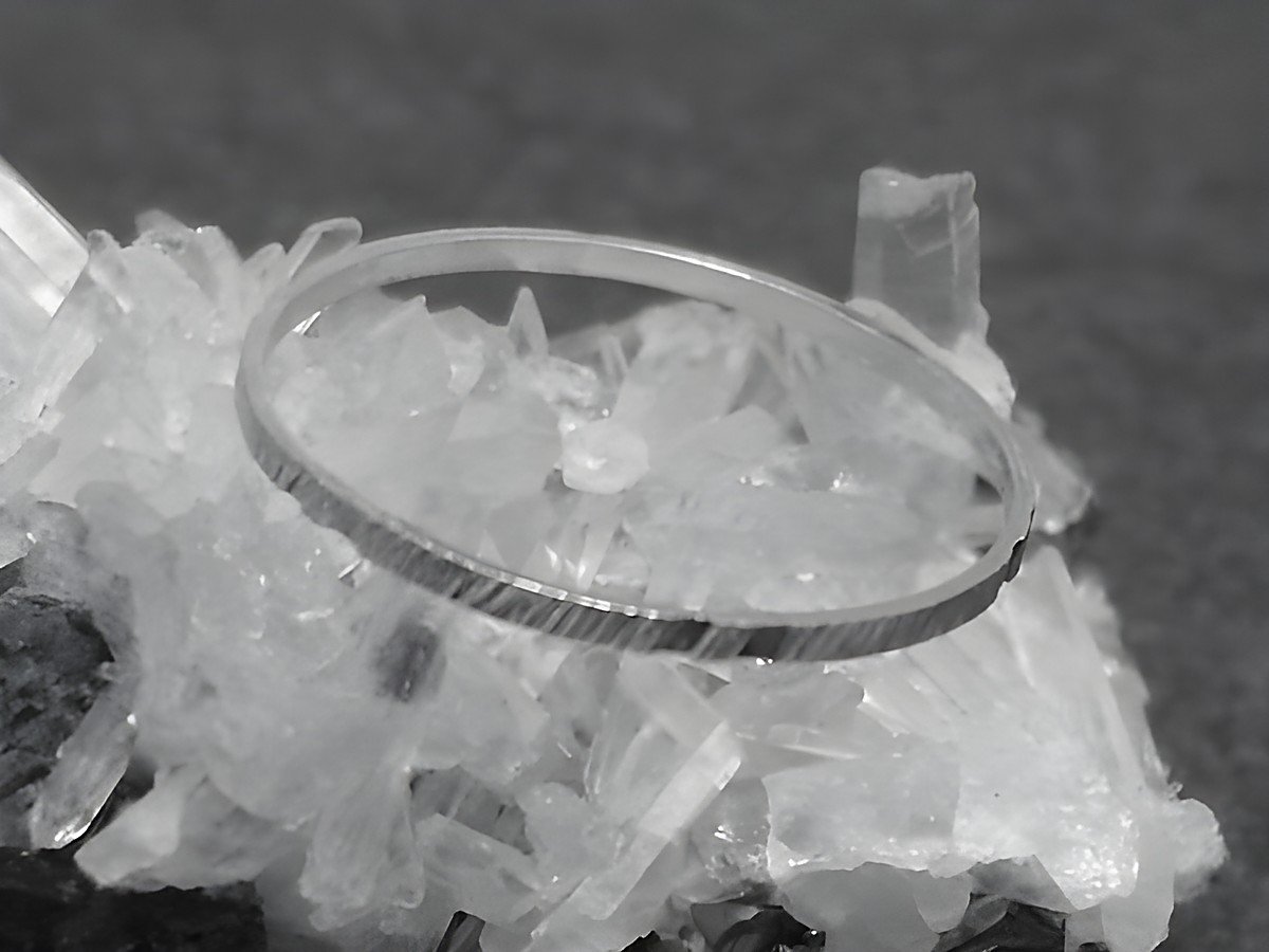 Silber Ring rhodiniert 1mm breit in Größe 60 beziehungsweise 19mm, präsentiert auf kristallinem Untergrund, Hersteller Juwelier Harnisch.