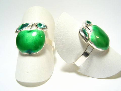Designer Silber Ring rhodiniert -Apfel- in grün, Hersteller Juwelier Harnisch, ohne Stein, zeigt einen stilisierten grünen Apfel als Ringdesign auf einem weißen Träger.