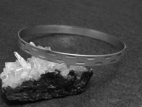 32631-0 Silber Armreifen mit Diamantschliff in 6 mm, rhodiniert und 20 cm lang, präsentiert auf schwarzem Untergrund und grauem Gestein, Hersteller Juwelier Harnisch, elegant und zeitlos.
