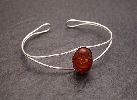 Bernstein Cabochon 17 cm Sterling Silber Armreifen von Juwelier Harnisch mit einem ovalen Bernstein in der Mitte und einem eleganten, offenen Design, Umfang 17 cm.