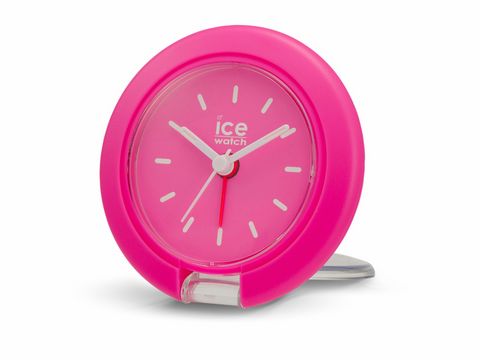 Ein neonpinker Reisewecker von Ice Watch mit einem Durchmesser von 7,5 cm. Er hat ein schlichtes Zifferblatt mit weißen Zeigern und einem stabilen Standfuß.