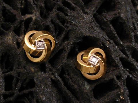 Ohrringe aus Gold 585 mit einem Brillanten von 0,03 ct W/P1, Hersteller Juwelier Harnisch, elegante Design mit geschwungenen Formen und funkelndem Diamant.
