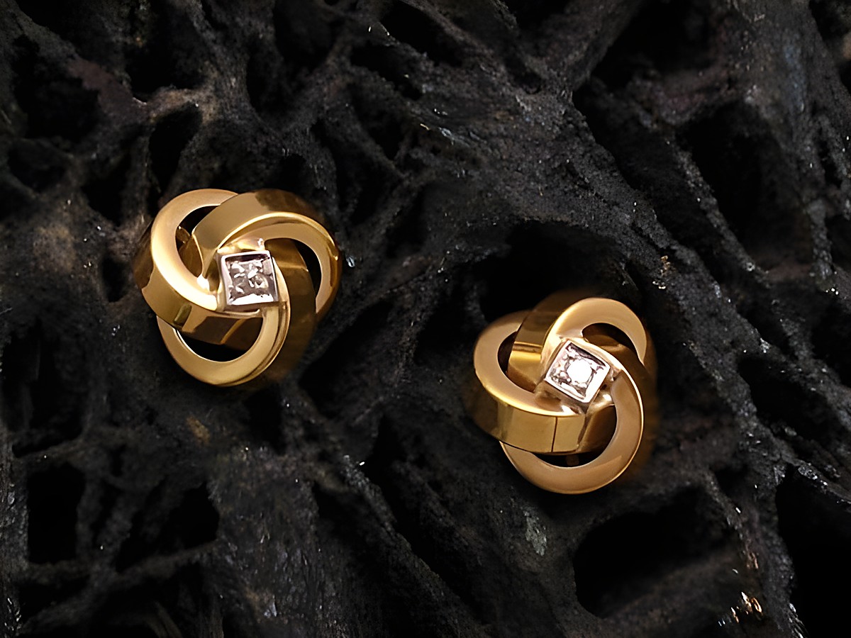 Ohrringe aus Gold 585 mit einem Brillanten von 0,03 ct W/P1, Hersteller Juwelier Harnisch, elegante Design mit geschwungenen Formen und funkelndem Diamant.