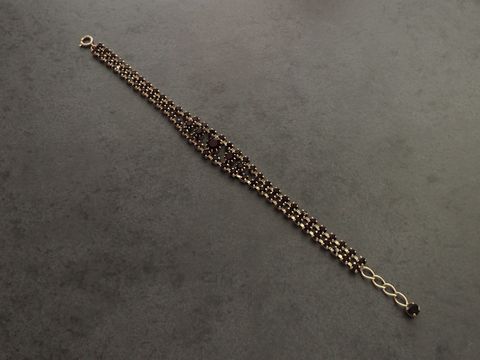 Strass Armband in granatroter Farbe mit goldfarbenen Akzenten, verstellbar von 19 bis 21,5 cm, gefertigt von Juwelier Harnisch, ideal für elegante Anlässe.
