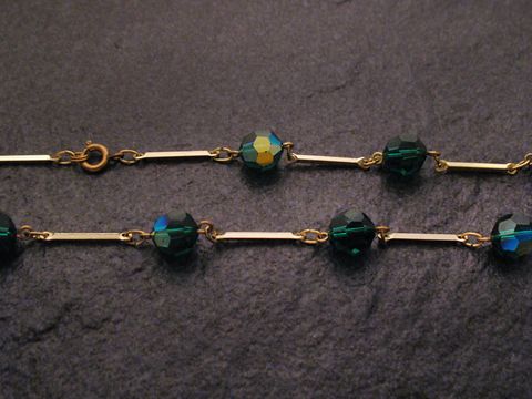 Grüne Strasskette, 54 cm lang, 10x10 mm breit, mit Facettenschliff-Steinen und goldenen Zwischenstücken, hergestellt von Juwelier Harnisch. Ideal für eleganten Schmuck.