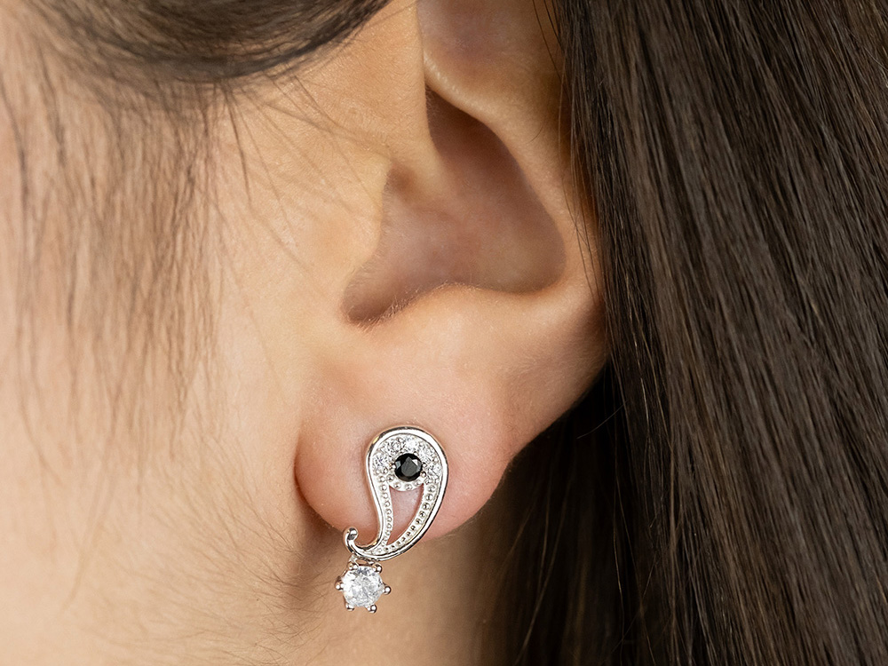 Silberne Ohrstecker mit Zirkonia und Yin Yang Symbol, elegant und modern, getragen am Ohr, das Licht reflektiert auf den glitzernden Steinen, perfektes Accessoire für jeden Anlass.