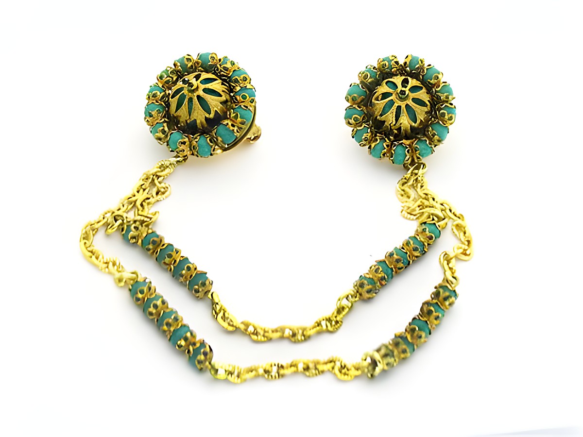 Wunderschöne Brosche in Türkis mit gefasstem Design, hergestellt von Juwelier Harnisch. Die Brosche präsentiert sich mit elegantem goldfarbenem Detail und bietet einen ansprechenden Türkis-Look.
