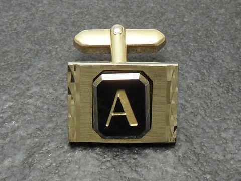 Vergoldete Manschettenknöpfe mit Initialen A, elegantes Design mit schwarzem Stein und facettiertem Rahmen, hergestellt von Juwelier Harnisch, ideal für besondere Anlässe.