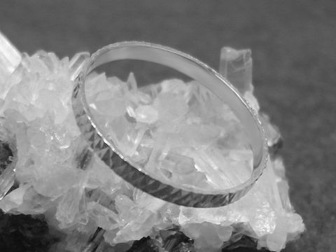 Silber Ring rhodiniert 2mm breit Größe 60 19mm auf einer Kristalloberfläche abgebildet, Hersteller Juwelier Harnisch ideal für modebewusste Träger.