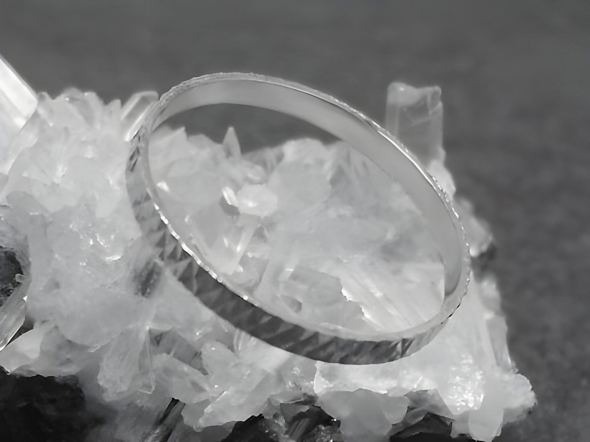 Silber Ring rhodiniert 2mm breit Größe 60 19mm auf einer Kristalloberfläche abgebildet, Hersteller Juwelier Harnisch ideal für modebewusste Träger.