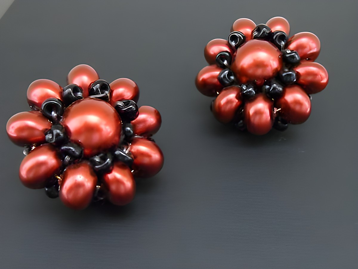 Ohrclip in rot-schwarz mit blumigem Design, verziert mit goldfarbenen Details und synthetischer Zuchtperle, hergestellt von Juwelier Harnisch, ideal für jeden Anlass.