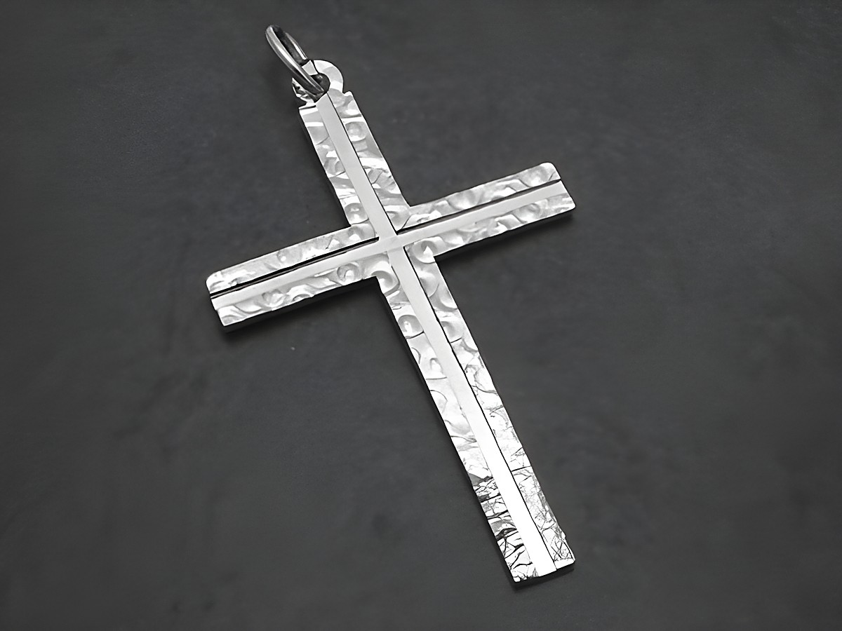 Silber Kreuz Anhänger mit Gravur und Design Muster, neu, Hersteller Juwelier Harnisch, zeigt ein glänzendes, gehämmertes Kreuz aus Silber mit detaillierter Oberflächenstruktur.