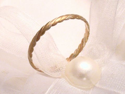 Trauring Ehering CEASELESS in Gold 333 mit gedrehter Oberfläche, Größe 60/19,1, Hersteller Juwelier Harnisch, elegant auf heller Schleife drapiert mit einer Perle.