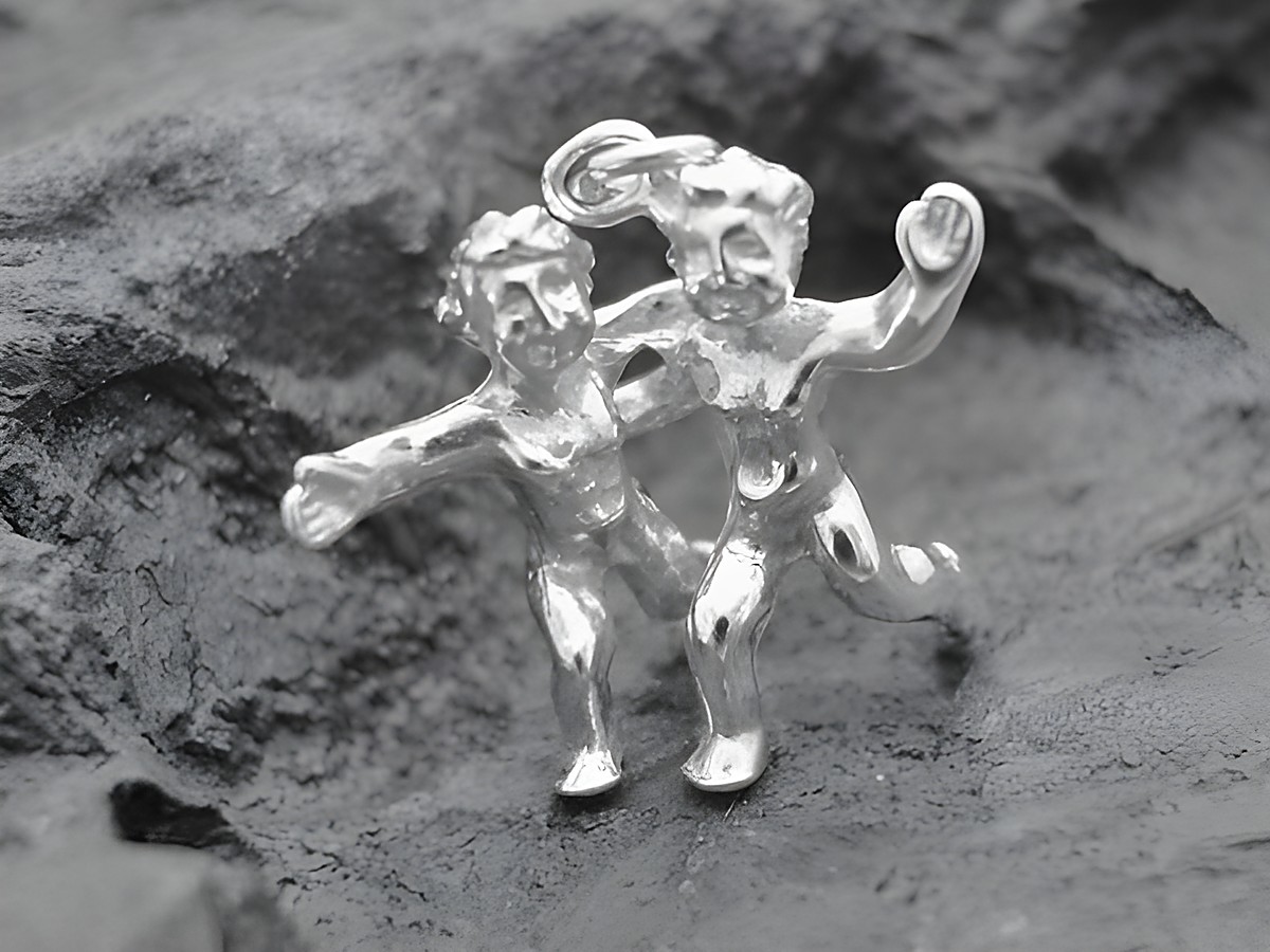 Silber Anhänger - Sternzeichen Zwillinge - vollplastisch, Hersteller: Juwelier Harnisch, zeigt zwei spielende Zwillingsfiguren aus Silber, detailliert gearbeitet und glänzend.