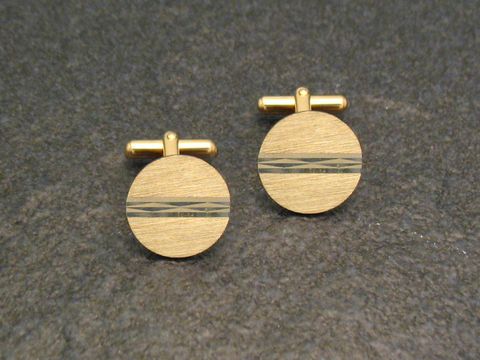 Vergoldete Manschettenknöpfe klein und dezent mit modernem Design, Hersteller Juwelier Harnisch, goldfarben, runde Form mit feinen Linien auf der Oberfläche.