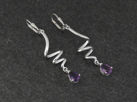 Elegante Ohrhänger aus rhodiniertem Sterling Silber mit geschwungener Form, verziert mit tropfenförmigen Amethyststeinen, ideal für stilvolle Anlässe von Juwelier Harnisch.