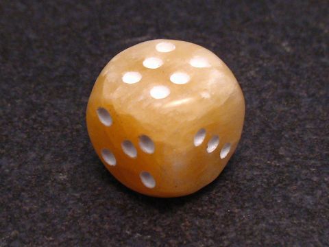 Steinwürfel ACHAT - Beige - GLÜCKSBRINGER von Juwelier Harnisch, edel geschliffen mit weißen Punkten, auf dunklem Hintergrund präsentiert, ideal als Geschenk oder zur positiven Energie.