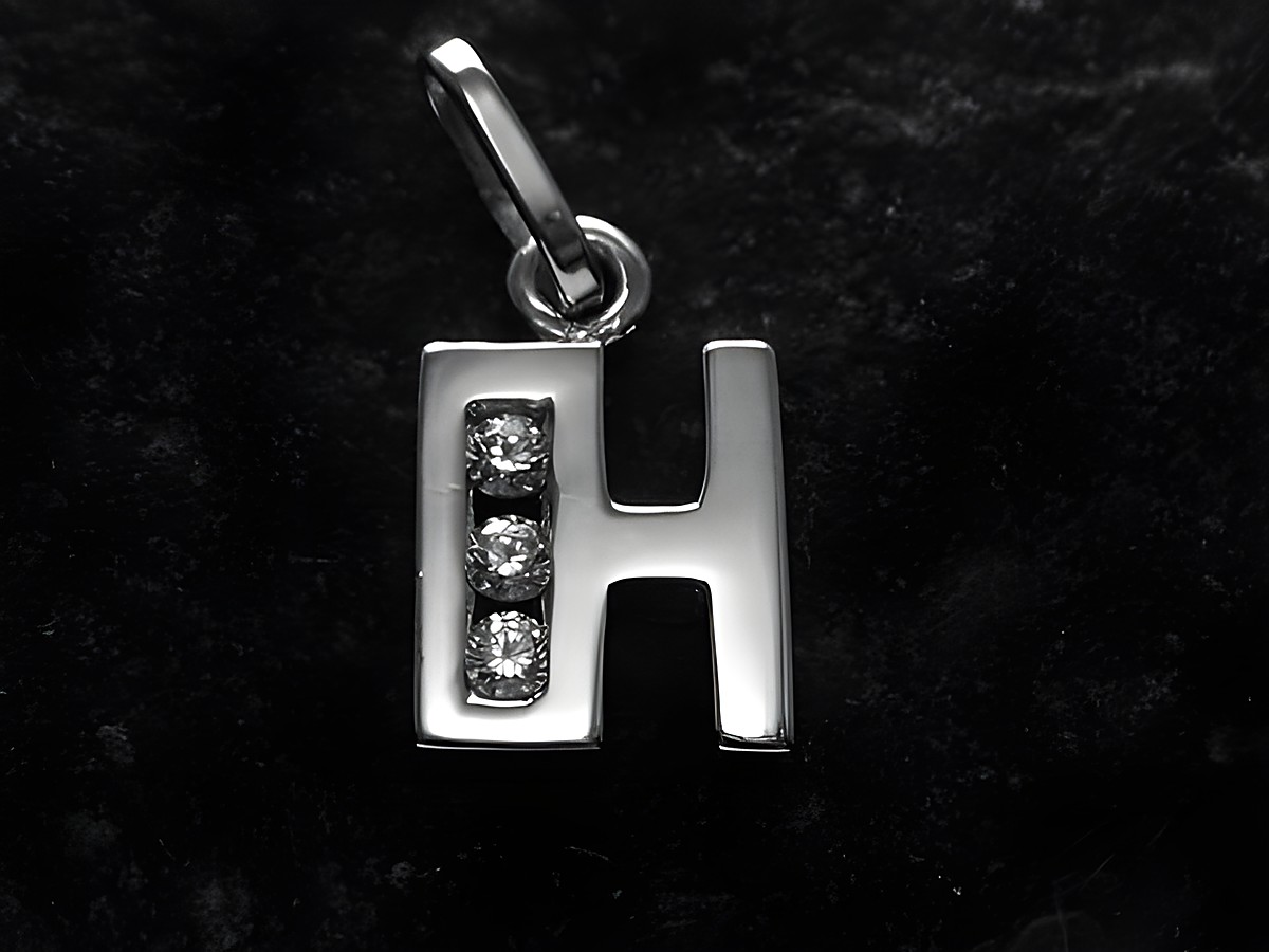 Anhänger aus rhodiniertem Silber in Form des Buchstabens H, verziert mit drei Zirkonia. Hersteller Juwelier Harnisch, ideal für personalisierte Schmuckstücke.