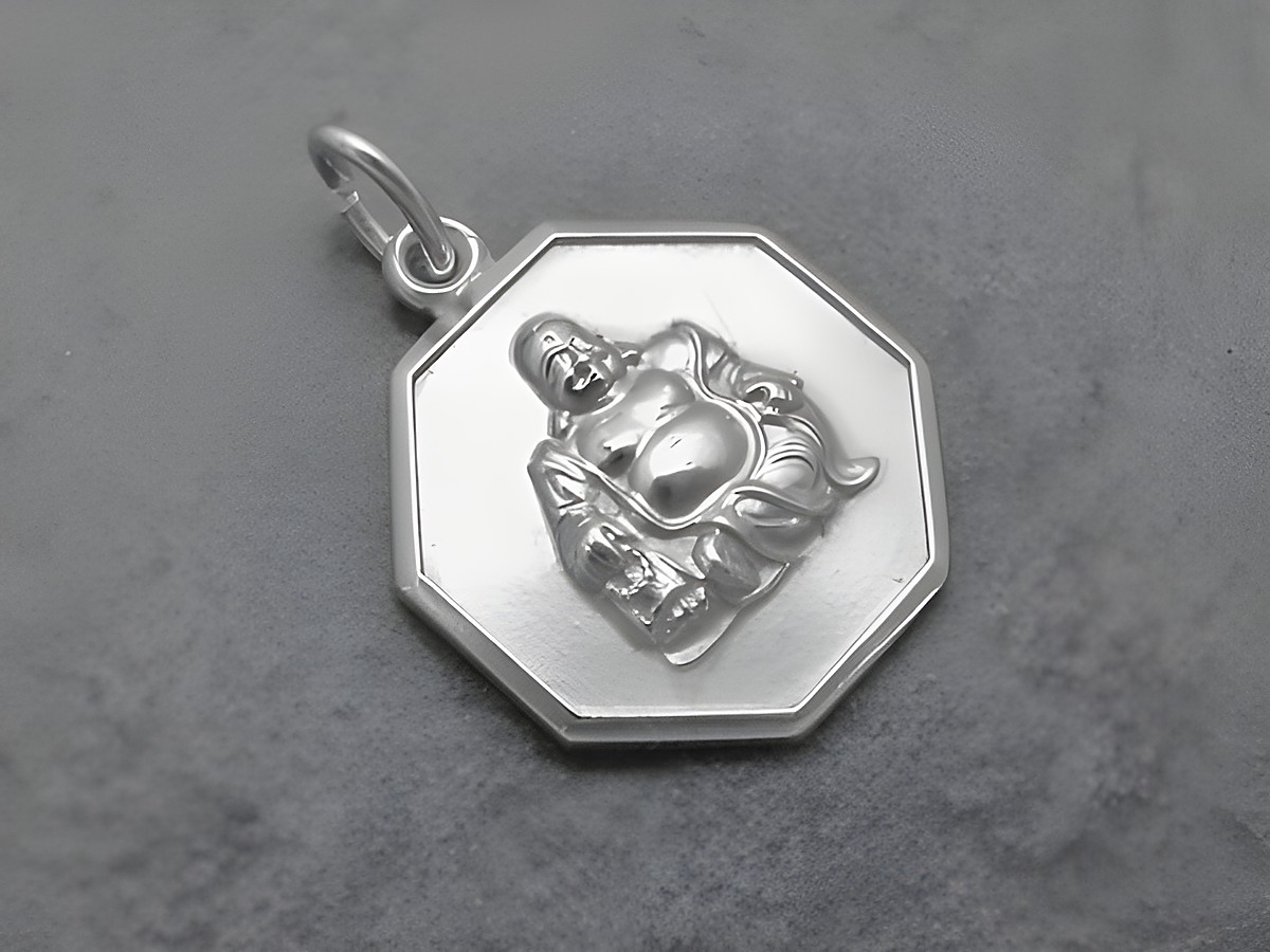 Silber Anhänger mit Buddha-Motiv als Glücksbringer, rund um das Buddha-Relief eine achteckige Form, Hersteller Juwelier Harnisch, religiöses Schmuckstück.