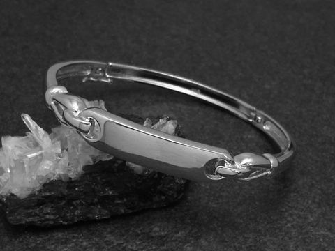 Silber Armreifen cultig 8,6 mm rhodiniert 17 cm von Juwelier Harnisch, zeitloses Design in eleganter Form, abgebildet auf schwarzem Untergrund mit glitzernden Kristallen.