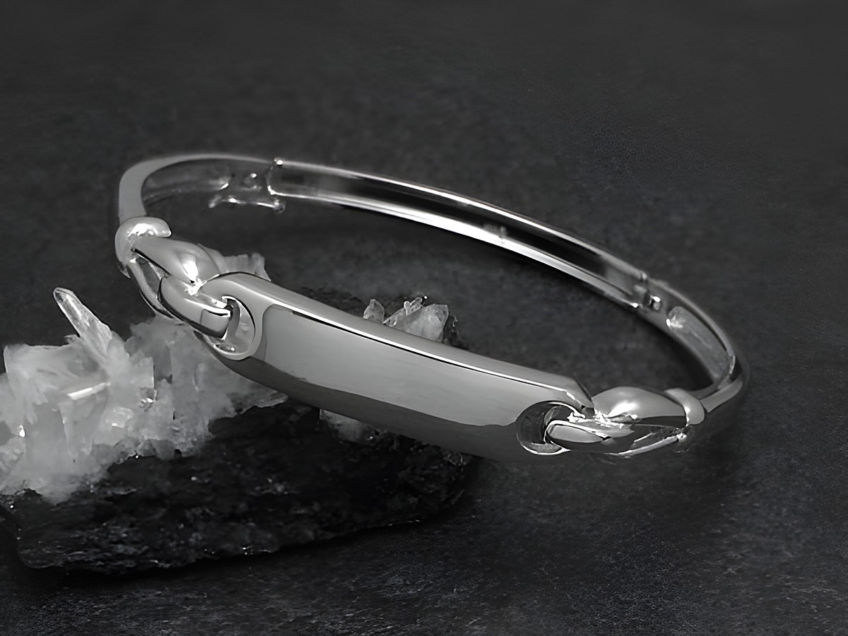 Silber Armreifen cultig 8,6 mm rhodiniert 17 cm von Juwelier Harnisch, zeitloses Design in eleganter Form, abgebildet auf schwarzem Untergrund mit glitzernden Kristallen.