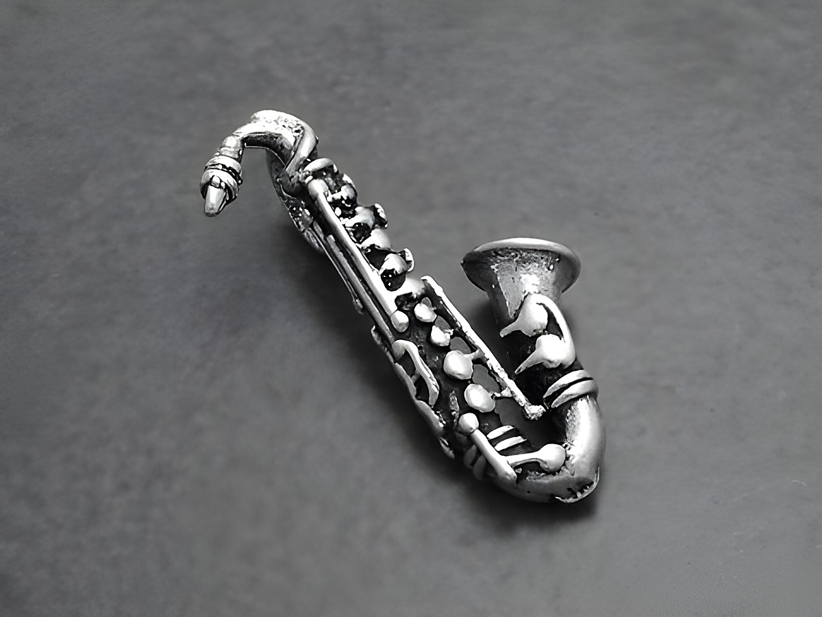 Silberner Saxophon Anhänger aus dem Hause Juwelier Harnisch, stilvolles Musikinstrument für Musikliebhaber, perfektes Accessoire für jedes Outfit, ideal als Geschenk oder zum Selbsttragen.