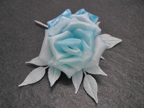 Verspielt gestalteter Haarschmuck in Form einer hellblauen Samt-Mix Blume mit zarten, weißen Blättern, ideal als Brosche, hergestellt von Juwelier Harnisch.