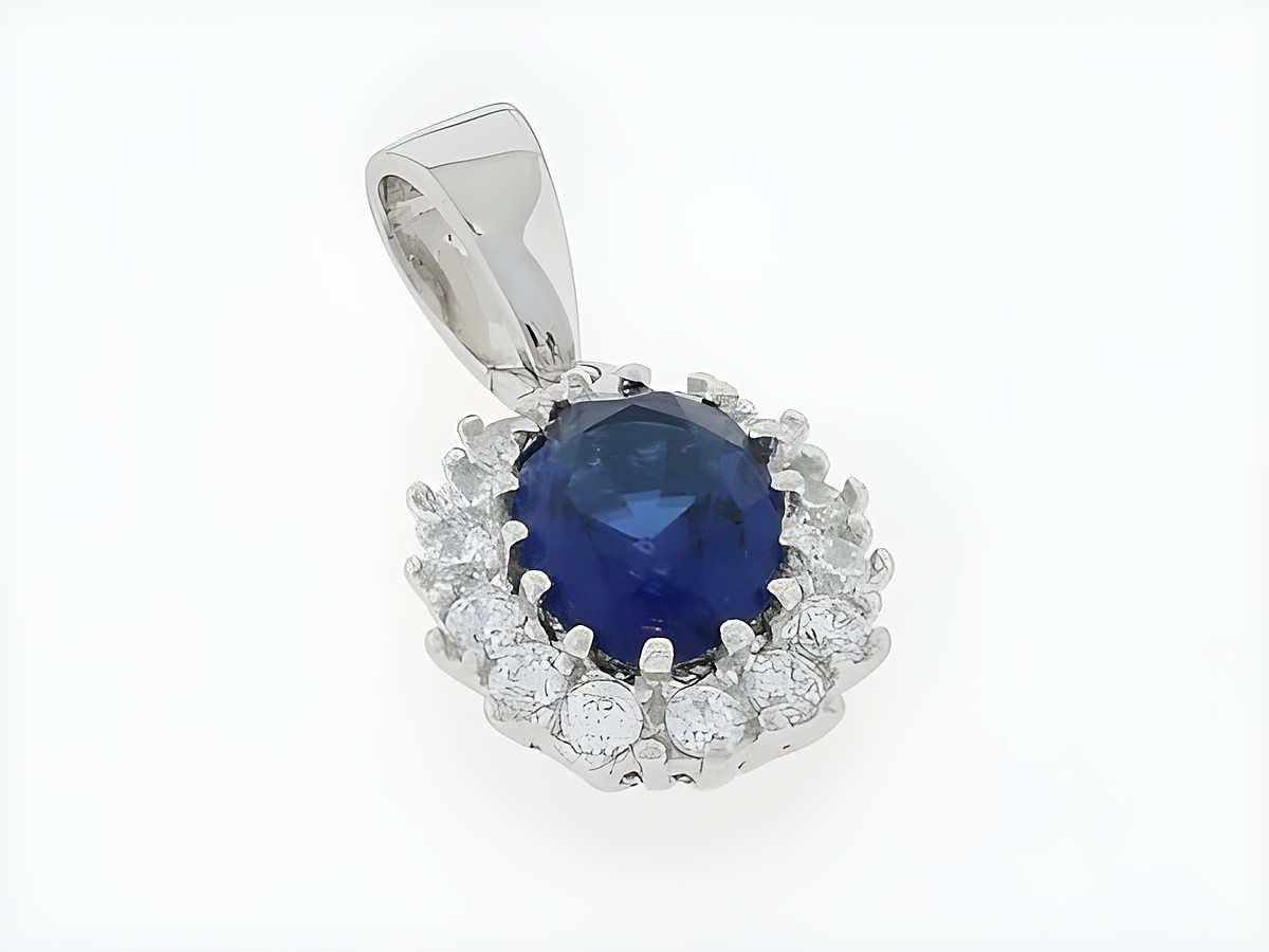 Silber Anhänger in ovaler Form mit glitzerndem Zirkonia in dunkelblau, umgeben von weiteren Zirkonia-Materialien, hergestellt von Juwelier Harnisch.