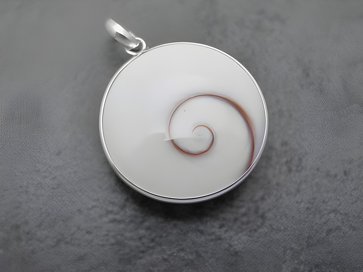 Symbolischer Anhänger in Rundform aus Silber mit einem weißen und braunen Shiva Auge, hergestellt von Juwelier Harnisch, als Glücksbringer gestaltet.