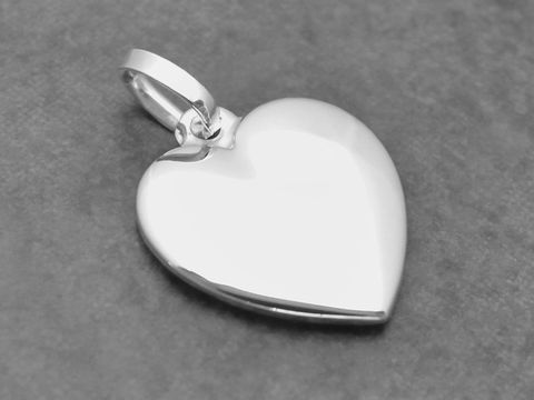 Silber Anhänger in Herzform, ausdruckstark und flach, hergestellt von Juwelier Harnisch, ideal als Schmuckstück für besondere Anlässe oder als Geschenk.