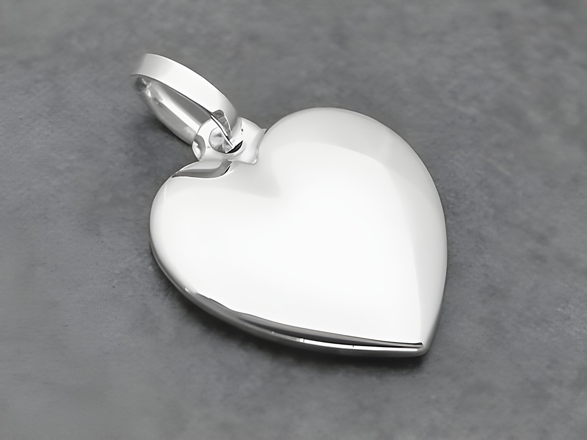 Silber Anhänger in Herzform, ausdruckstark und flach, hergestellt von Juwelier Harnisch, ideal als Schmuckstück für besondere Anlässe oder als Geschenk.