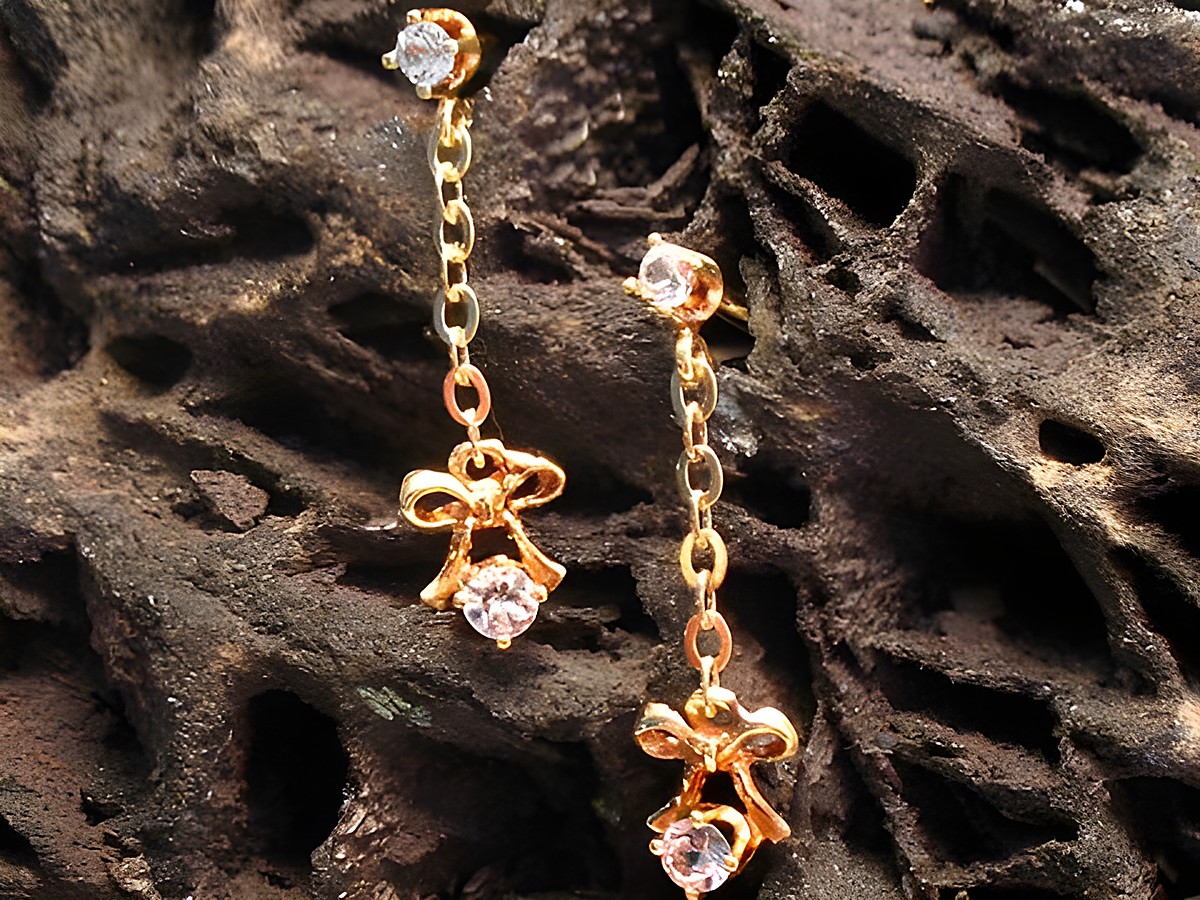 Verspielte Gold 585 Ohrhänger mit Zirkonia, gefertigt vom Juwelier Harnisch, elegant gestaltet mit einem Stein und einer hübschen Schleifenform. Ideal für festliche Anlässe.