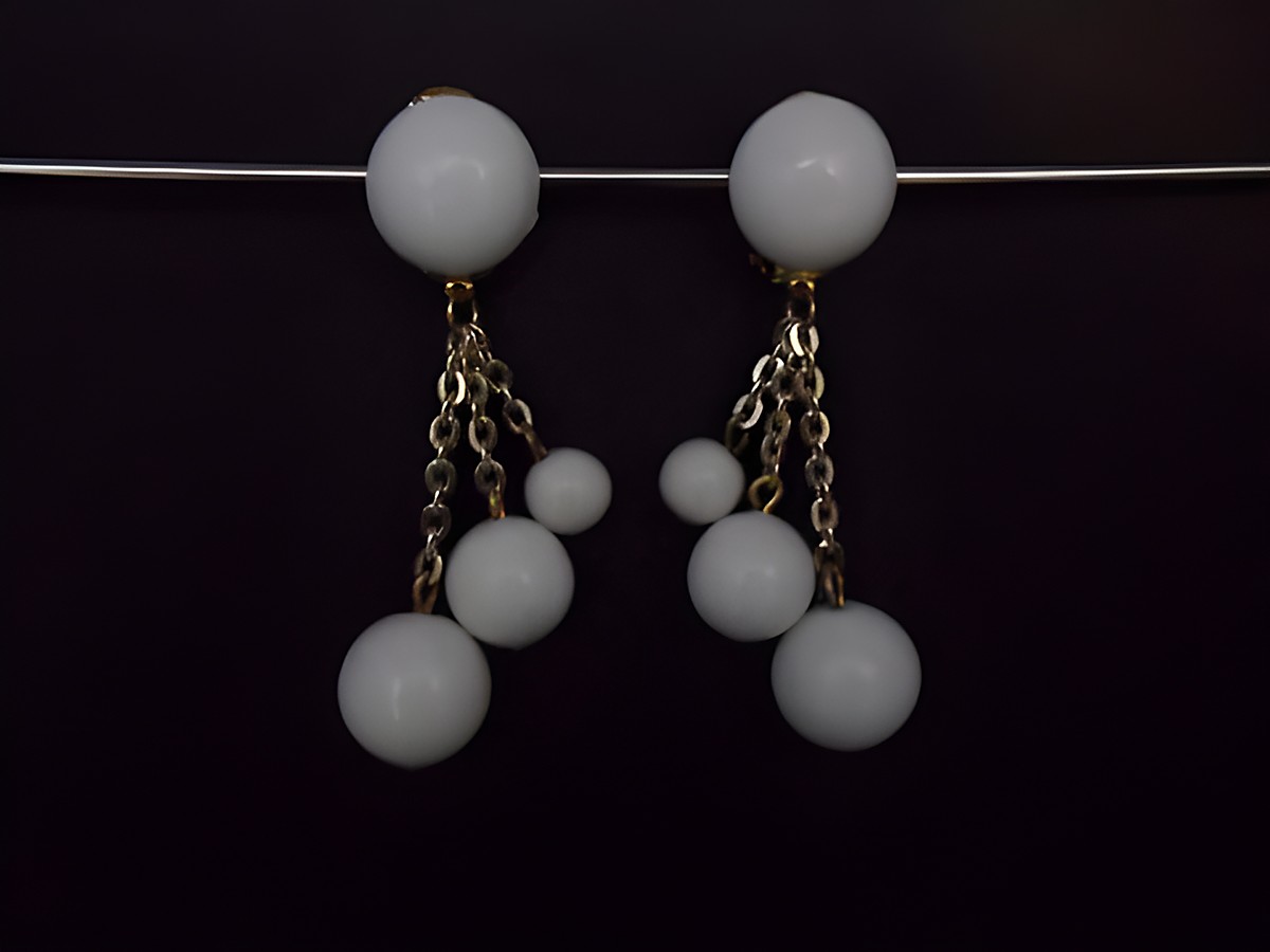 Ohrclip in Sommerweiß mit zeitlosem Design, goldfarbene Ketten und Kunstharzperlen. Hersteller ist Juwelier Harnisch, ideal für elegante Anlässe.
