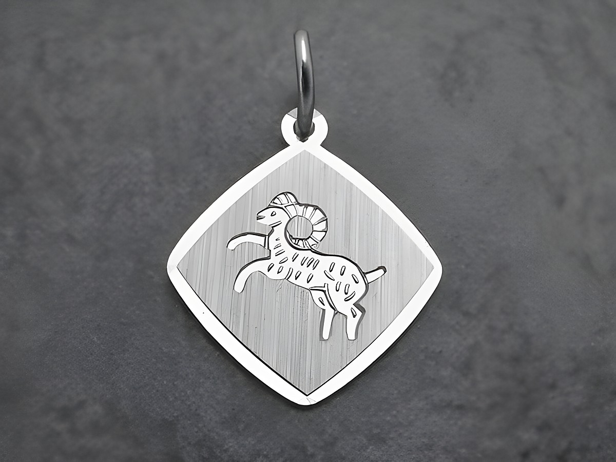 Sterling Silber rhodiniertes Anhänger für das Sternzeichen Widder, dargestellt durch einen laufenden Widder auf rechteckigem, strukturiertem Hintergrund, hergestellt von Juwelier Harnisch.