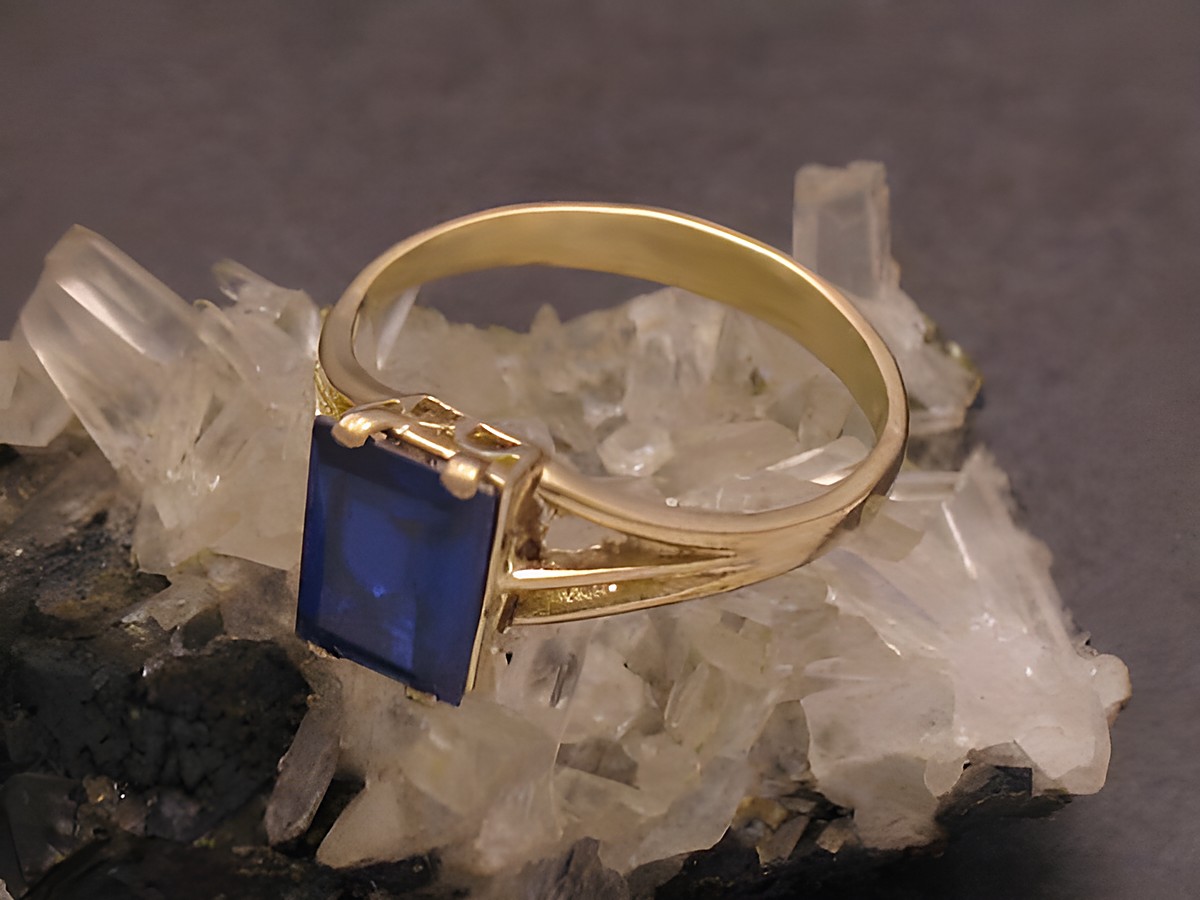 Goldring aus Gold 333 mit unechtem blauen Stein in Größe 56, Hersteller Juwelier Harnisch, elegant auf Kristallen präsentiert.